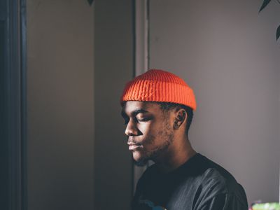 穿着橙色小豆豆冥想的黑人男子