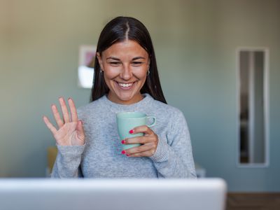 Lady waving at a computer on a video call