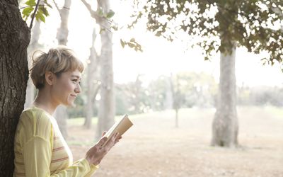 日本妇女阅读书在公园