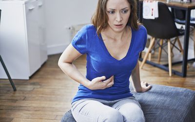 体验胃灼热的女人。