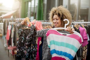 在市场上，一位女士在两件衣服之间做出选择