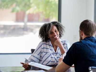 Confident mature businesswoman attentively listens during a meeting with a male associate.