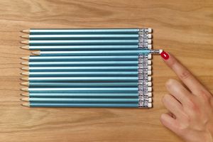 女士把铅笔推到与其他铅笔平齐的位置