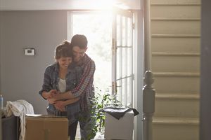 一对夫妇在新的家里嬉戏地拥抱
