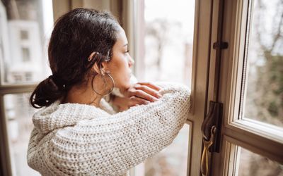 望着窗外,沉思的女人。