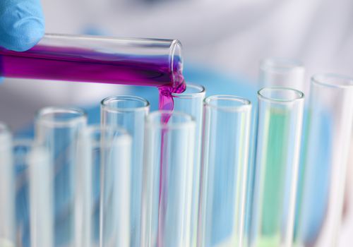 Male chemist holds test tube of glass in hi