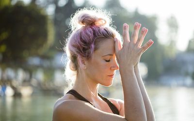 有染的头发的妇女思考在湖