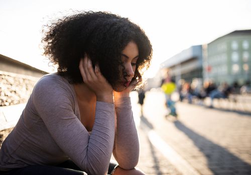 black-woman-on-bench-looking-sad