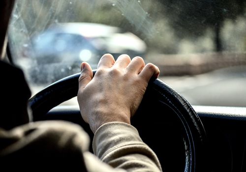 Cropped Image Of Man Driving Car On Road“class=