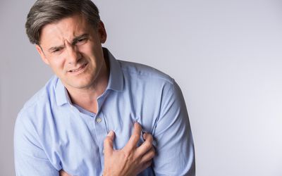 焦虑出现的男人手里拿着他的胸部疼痛