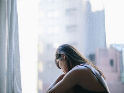sad woman in front of window