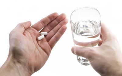 手里拿着药片的人