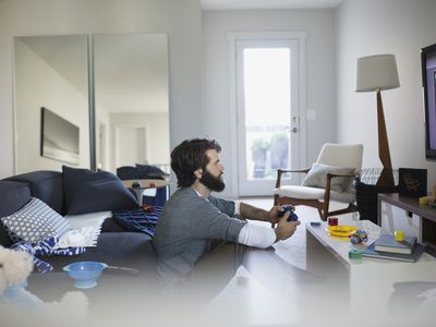 在客厅玩电子游戏的人