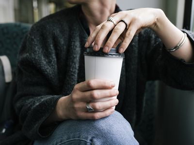 拿着纸制咖啡杯的女人