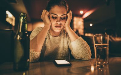 心烦意乱的女人在酒吧看手机