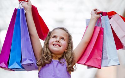 A picture of a child holding up shopping bags