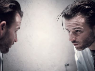 沉思的男人看着镜子