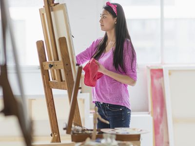 一个十几岁的女孩在画室里画画。