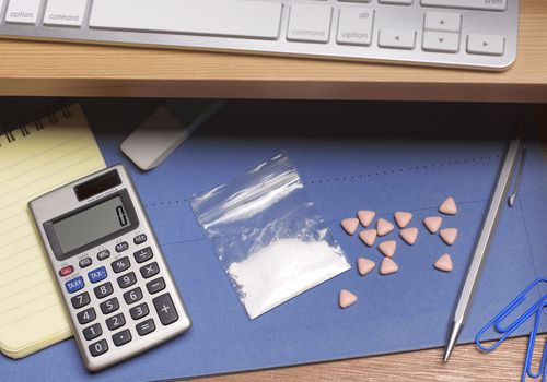 可卡因和狂热药片在办公桌前