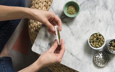 女人的手滚动大麻关节