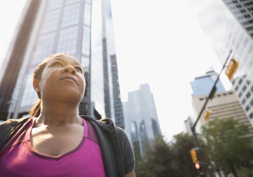 Serious, pensive mature woman below urban highrise