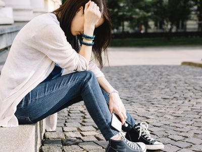 沮丧的女孩坐在街上