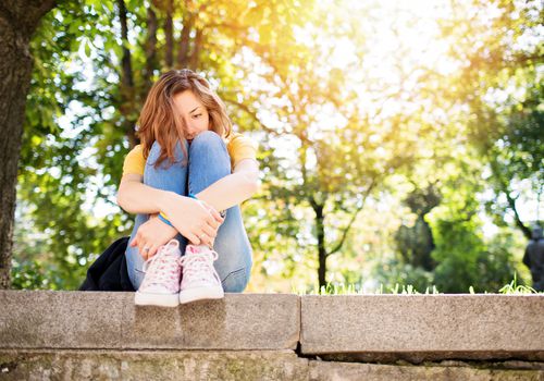 Sad woman sitting outside