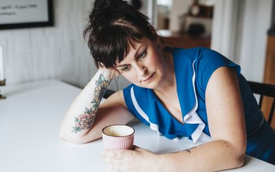 女人看起来沮丧 - 持有一杯咖啡