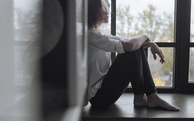 沮丧的少妇坐反对墙壁