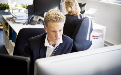 工作在他的书桌的年轻商人