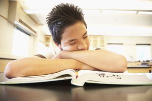 Young boy asleep on textbook