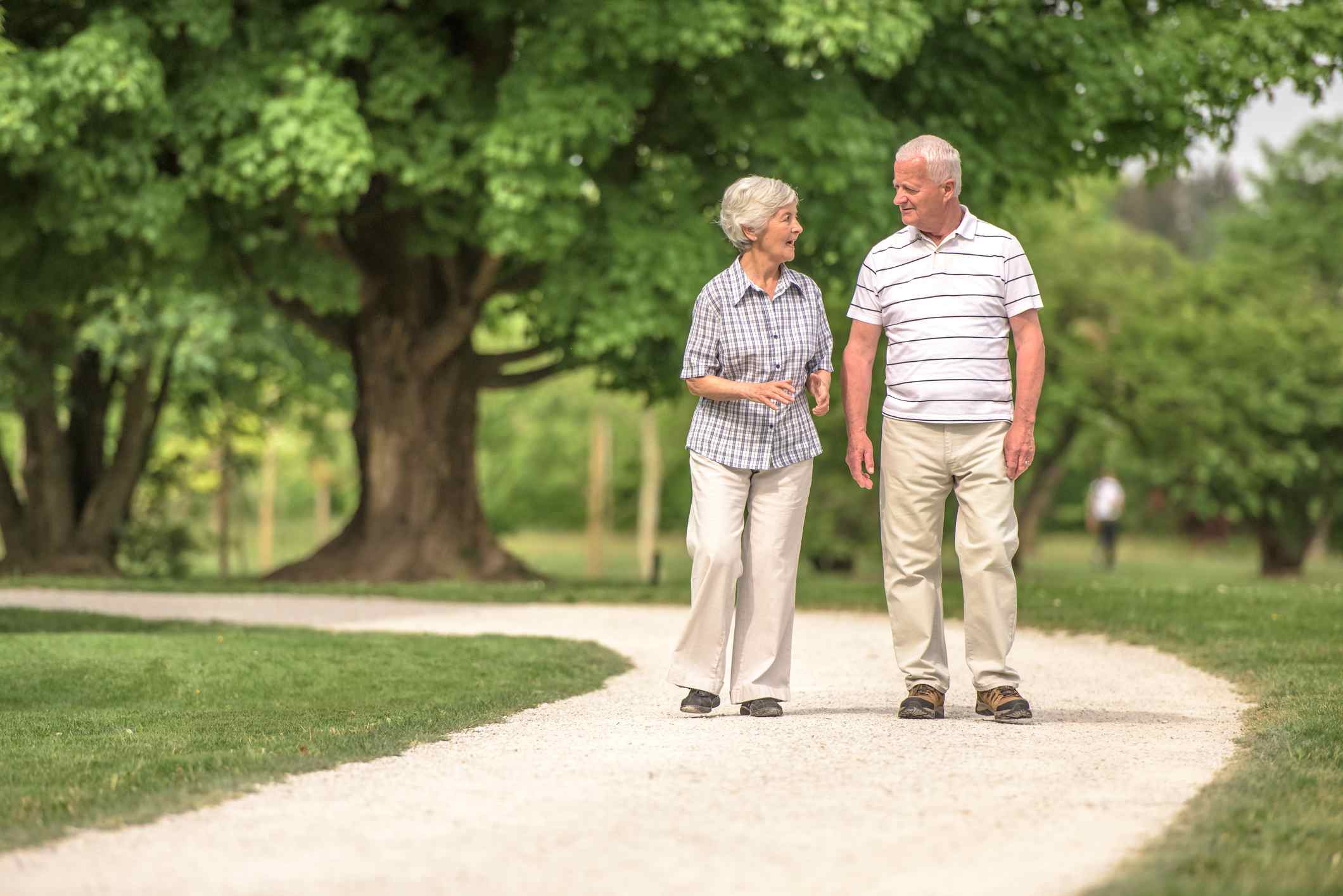 高级男人和女人走在公园路