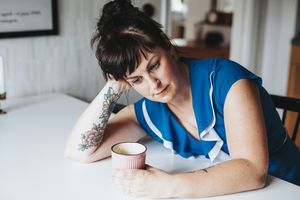 一名妇女在厨房餐桌前紧张地坐着