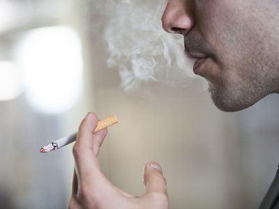 男人在吸烟，喷着烟