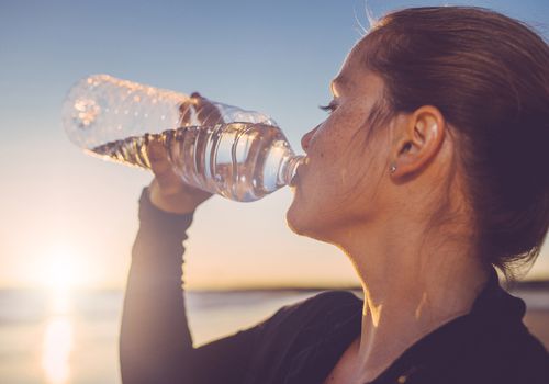 woman drinking water outside