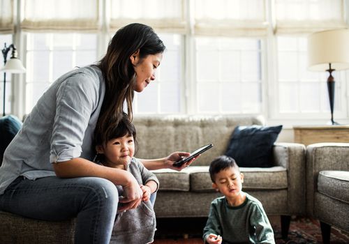 woman with two small children in living room