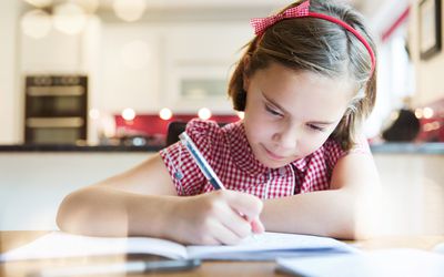 做家庭作业的女孩在厨房用桌上