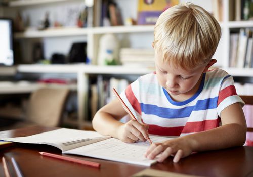 Young boy writing in workbook