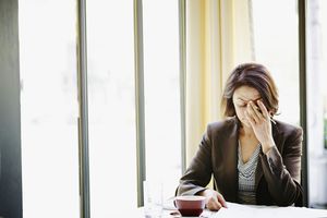 女商人在餐桌上将头搁在手上