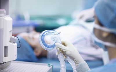 护士拿着麻醉面具在手术室里