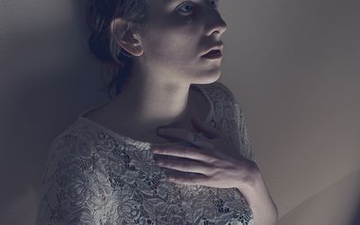 一个惊恐的女人靠在墙上