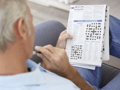 一位长者在思考报纸上的填字游戏