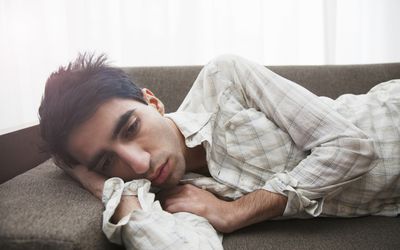 Man lying on sofa at home