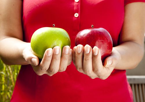 Woman comparing weights of apples