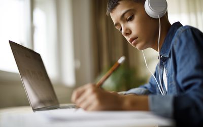 做作业的少年男孩听音乐