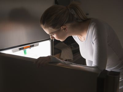 女人在晚上打开冰箱