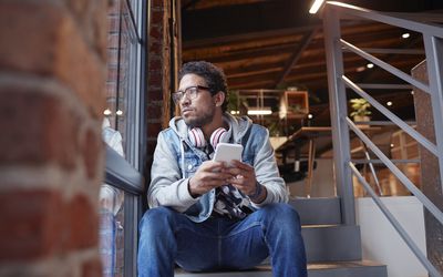 年轻人在创意创业公司工作，使用智能手机