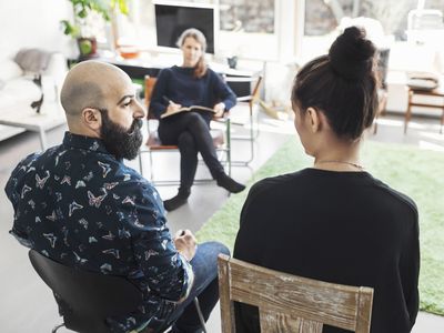 Couple talking to woman taking notes