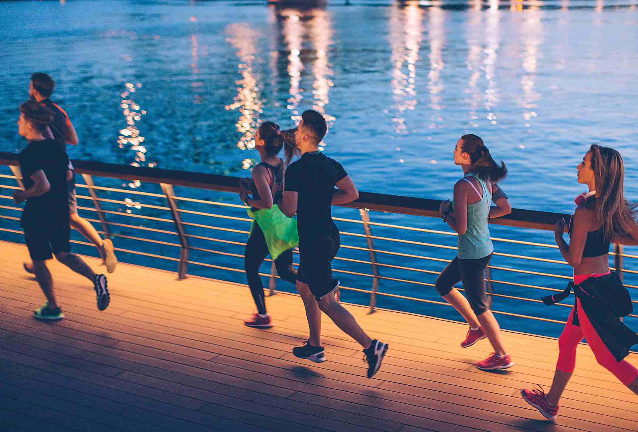 沿着海滨慢跑的男人和女人在晚上