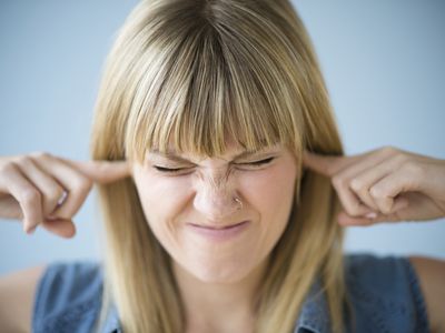 妇女用在她的耳朵的手。